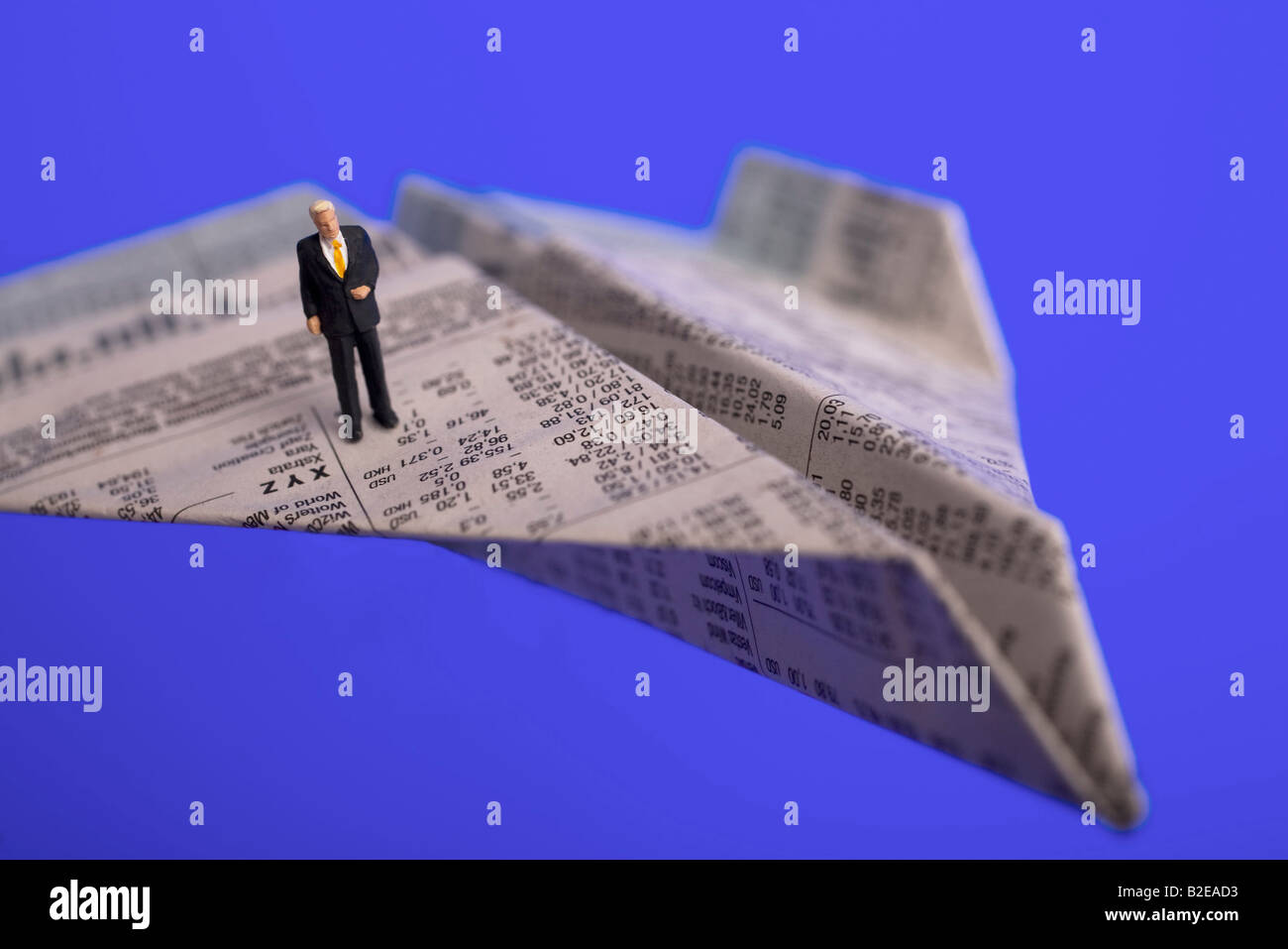 High angle view of figurine of businessman standing on paper airplane Stock Photo