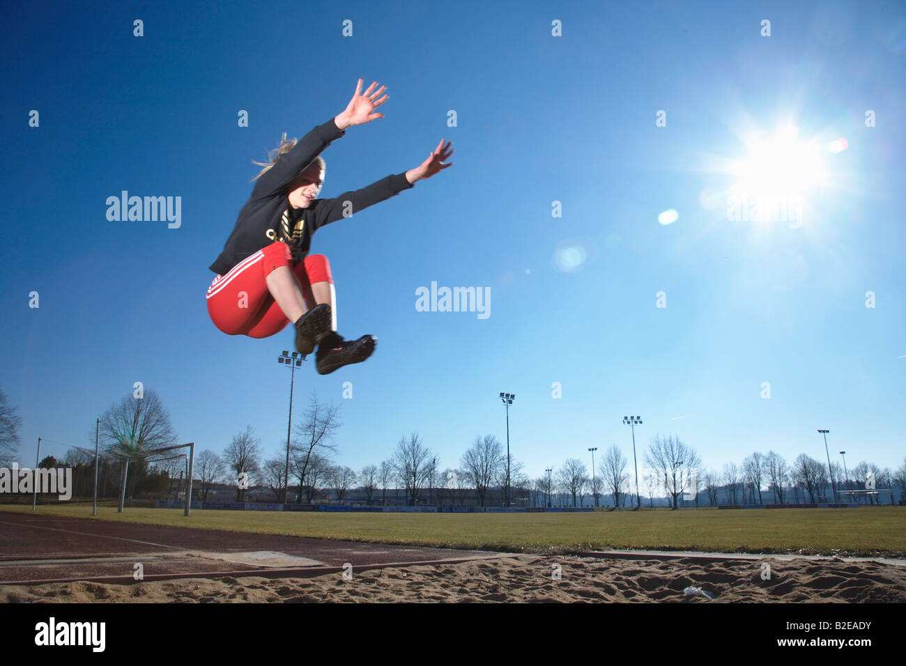 Female long jumper in mid-air Stock Photo