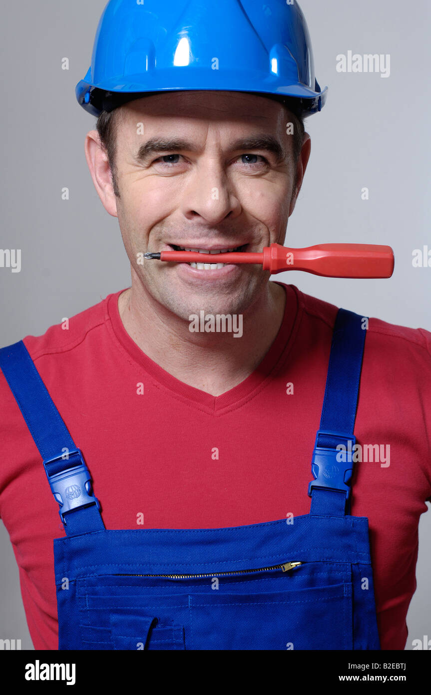 Portrait of man holding screwdriver in his mouth Stock Photo