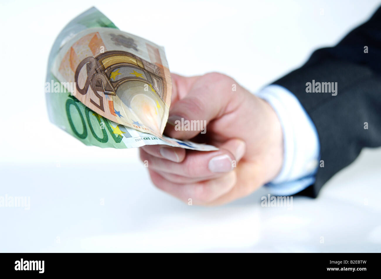 Close-up of person's hand offering European Union Euro notes Stock Photo