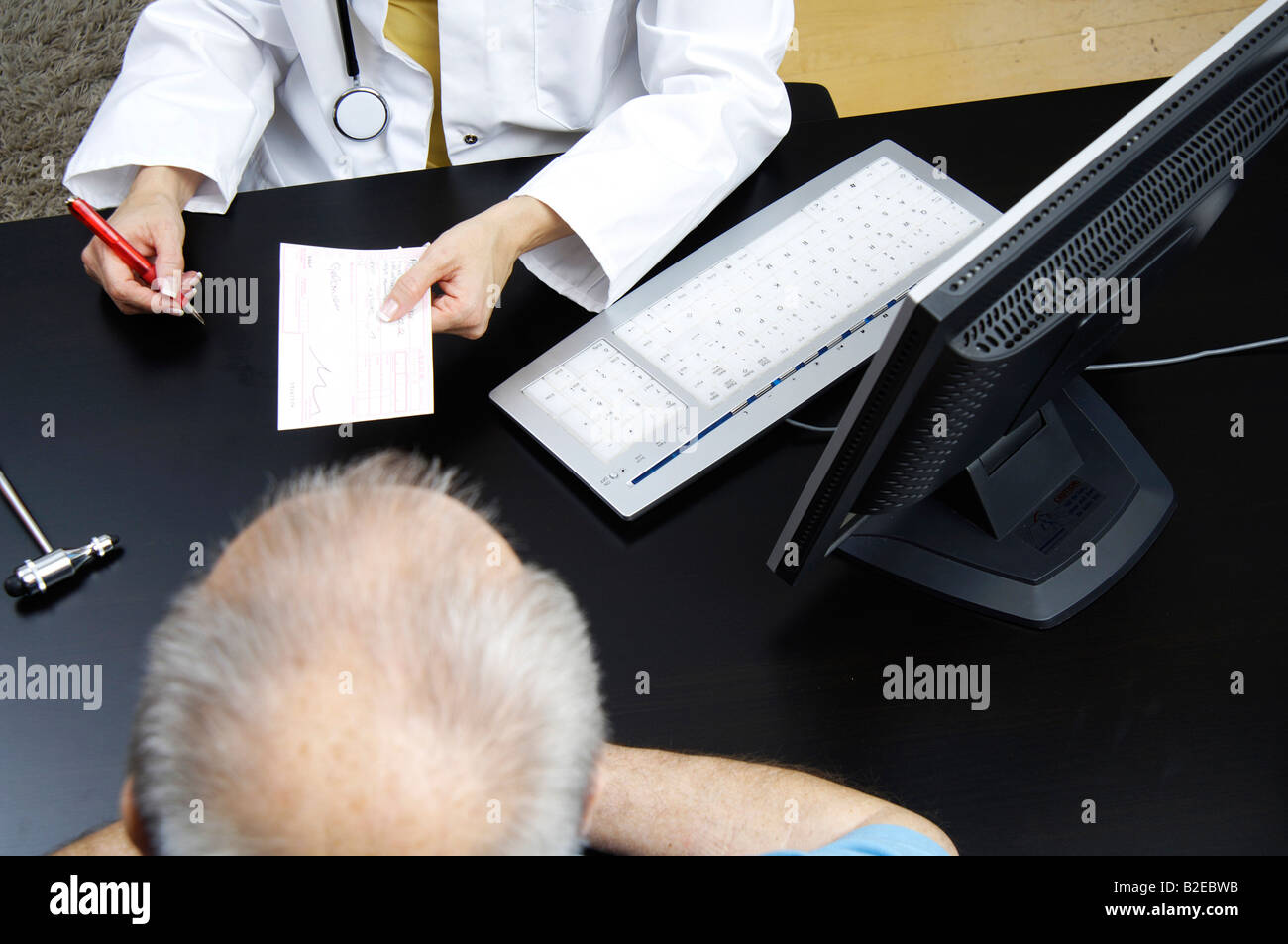 Mid section view of female doctor giving a prescription to patient Stock Photo