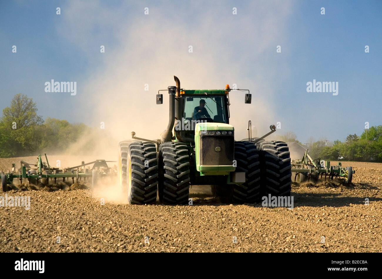 Large tractor cultivating spring soil in Lapeer County Michigan Stock Photo