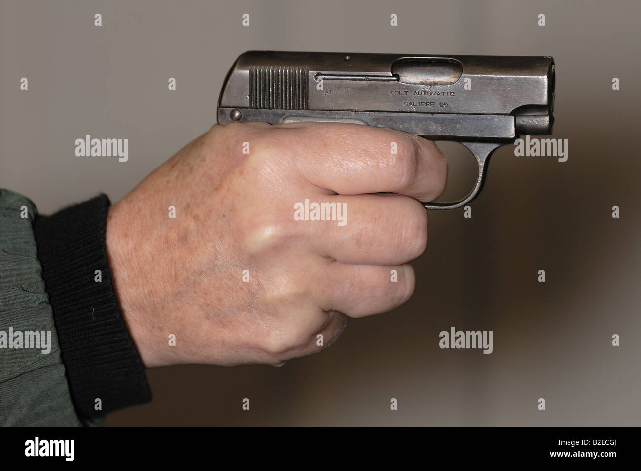 a small pistol held in hand and pointed or aimed Stock Photo