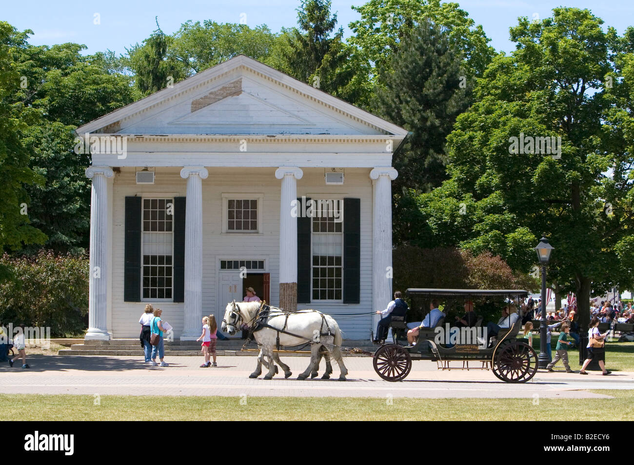 Horse drawn taxi passing the Town Hall in Greenfield Village at The Henry Ford in Dearborn Michigan Stock Photo