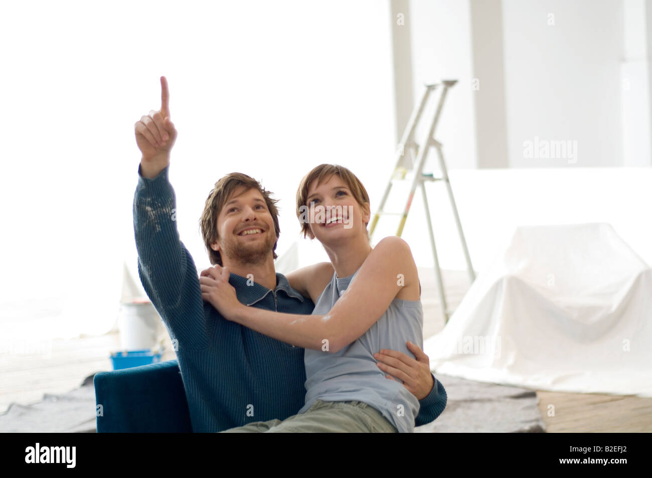 Young woman sitting on the lap of a mid adult man Stock Photo - Alamy