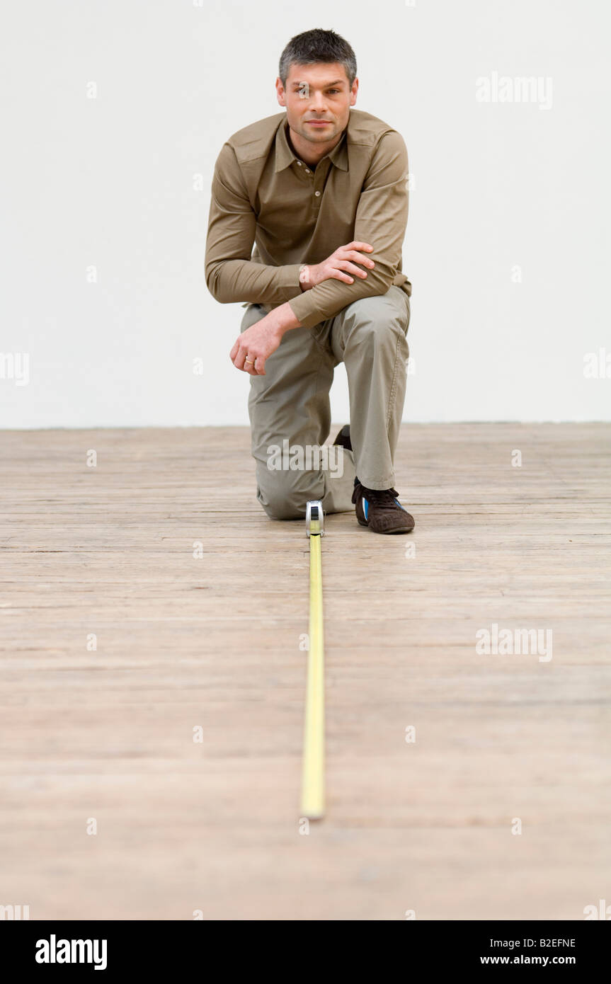 Interior designer measuring the hardwood floor with a tape measure