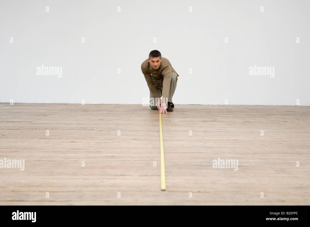 Interior designer measuring the hardwood floor with a tape measure Stock Photo
