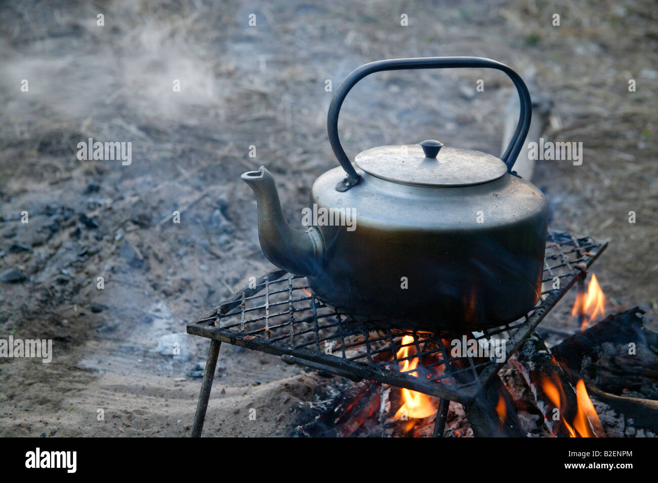 A kettle on a log fire heating water for coffee Stock Photo Alamy