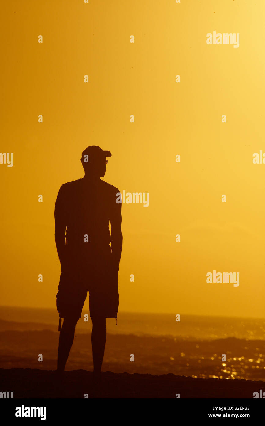 Sunset silhouette of a man on the beach Stock Photo - Alamy
