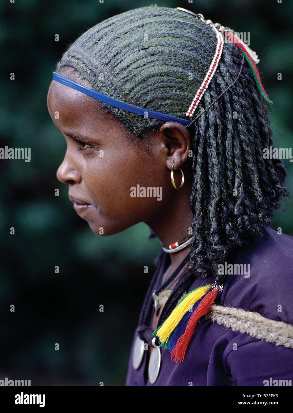 A young Ethiopian girl with unusual braided hair; the crown of her head has been smeared with a greenish substance. Stock Photo