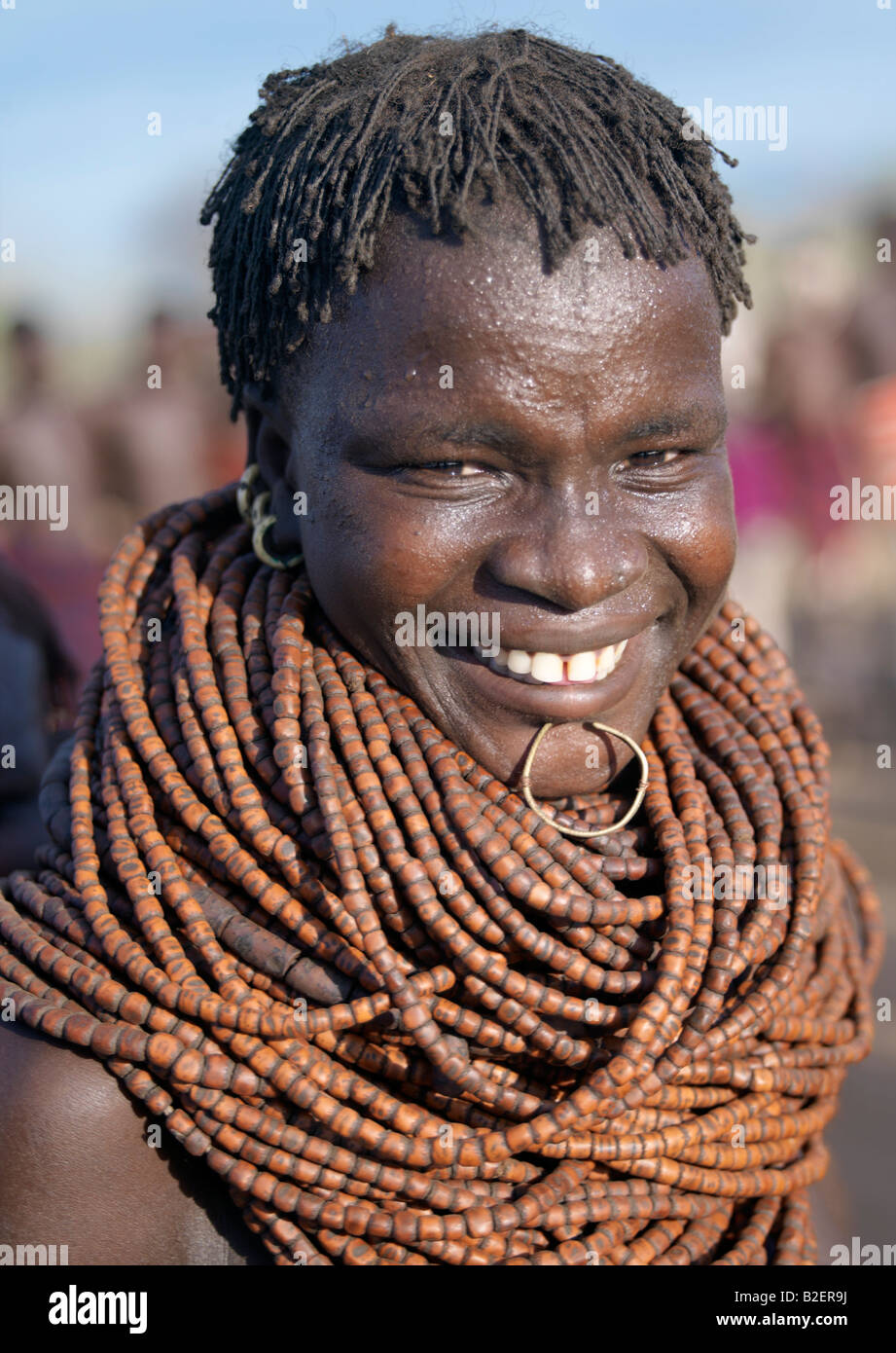 A Nyag'atom woman wears numerous strings of wooden beads and a small brass ring as a lip ornament. Stock Photo