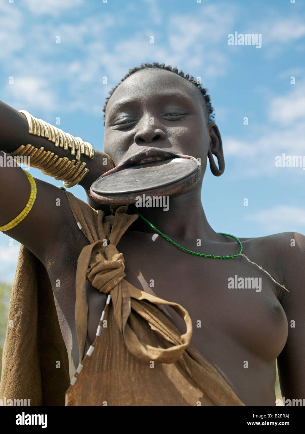 A Mursi woman wearing a large clay lip plate.Shortly before marriage, a girl's lower lip will be pierced and stretched. Stock Photo
