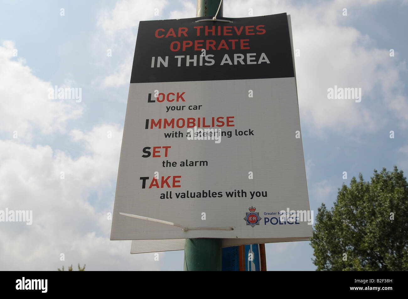 car thieves operate in this area poster sign manchester police lock your car  immobilise with a steering lock set the alarm Stock Photo