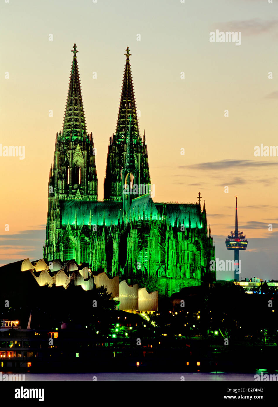 Koln Cologne Cathedral twin spires silhouetted floodlit against evening sky seen across the River Rhine, Germany Stock Photo