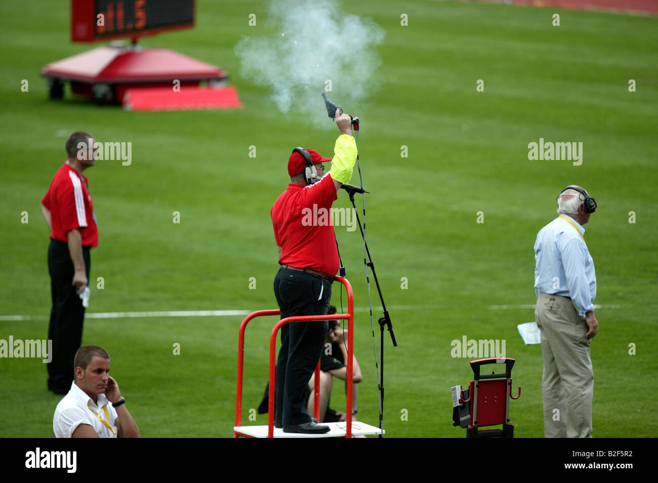 Bang  A starter on  a podium firing a starting pistol at the Aviva London Grand prix Stock Photo