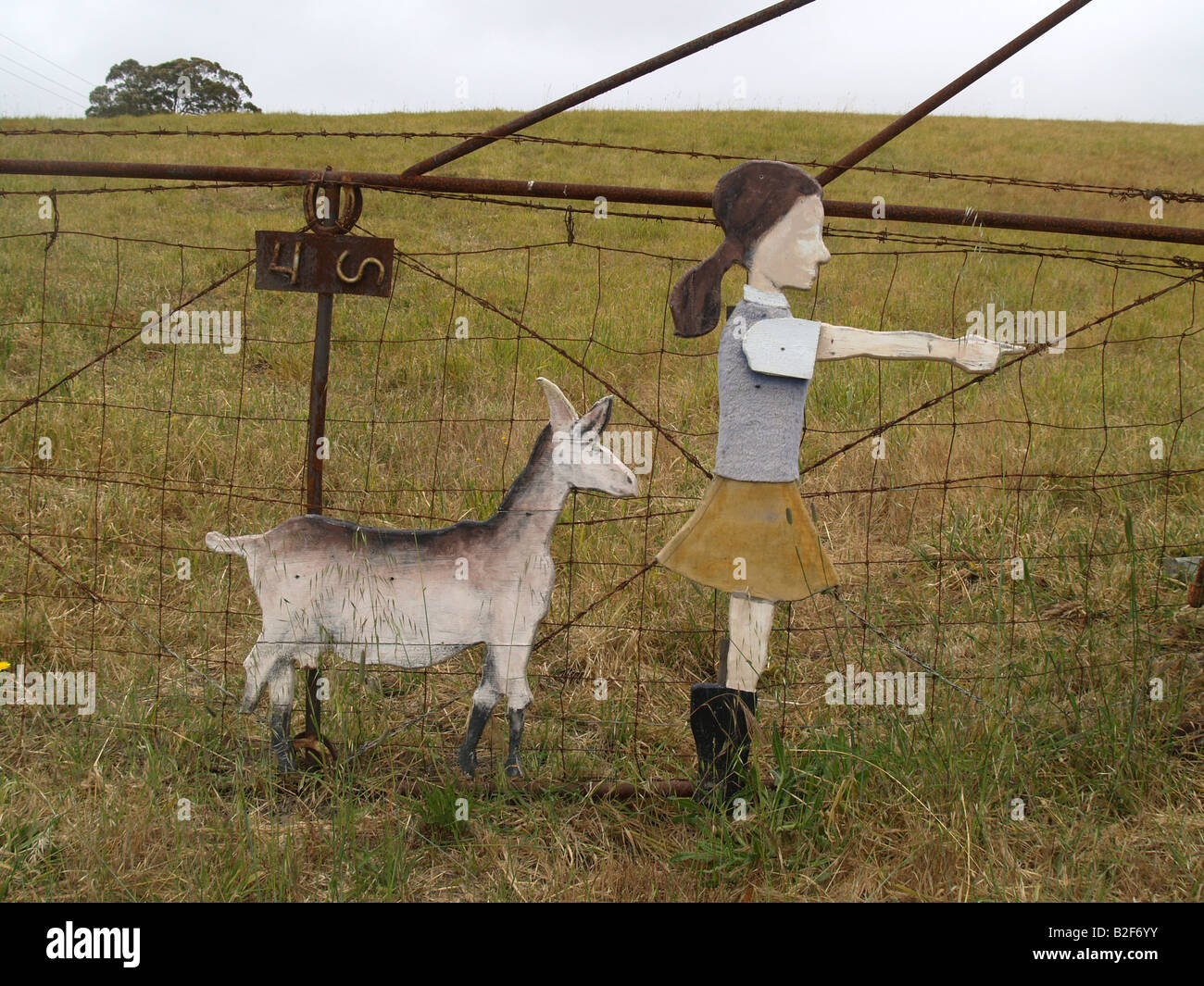 Girl and Goat wooden cut outs point to direction of goat farm Stock
