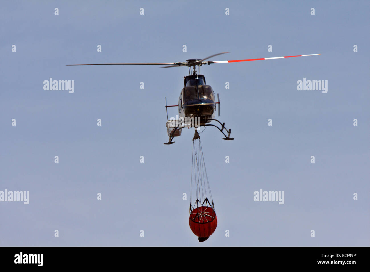 Helicopter carrying water to fire Stock Photo Alamy