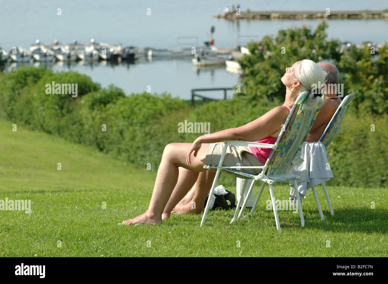 middle aged couple sunbathing, Rutland Water, England, UK Stock Photo