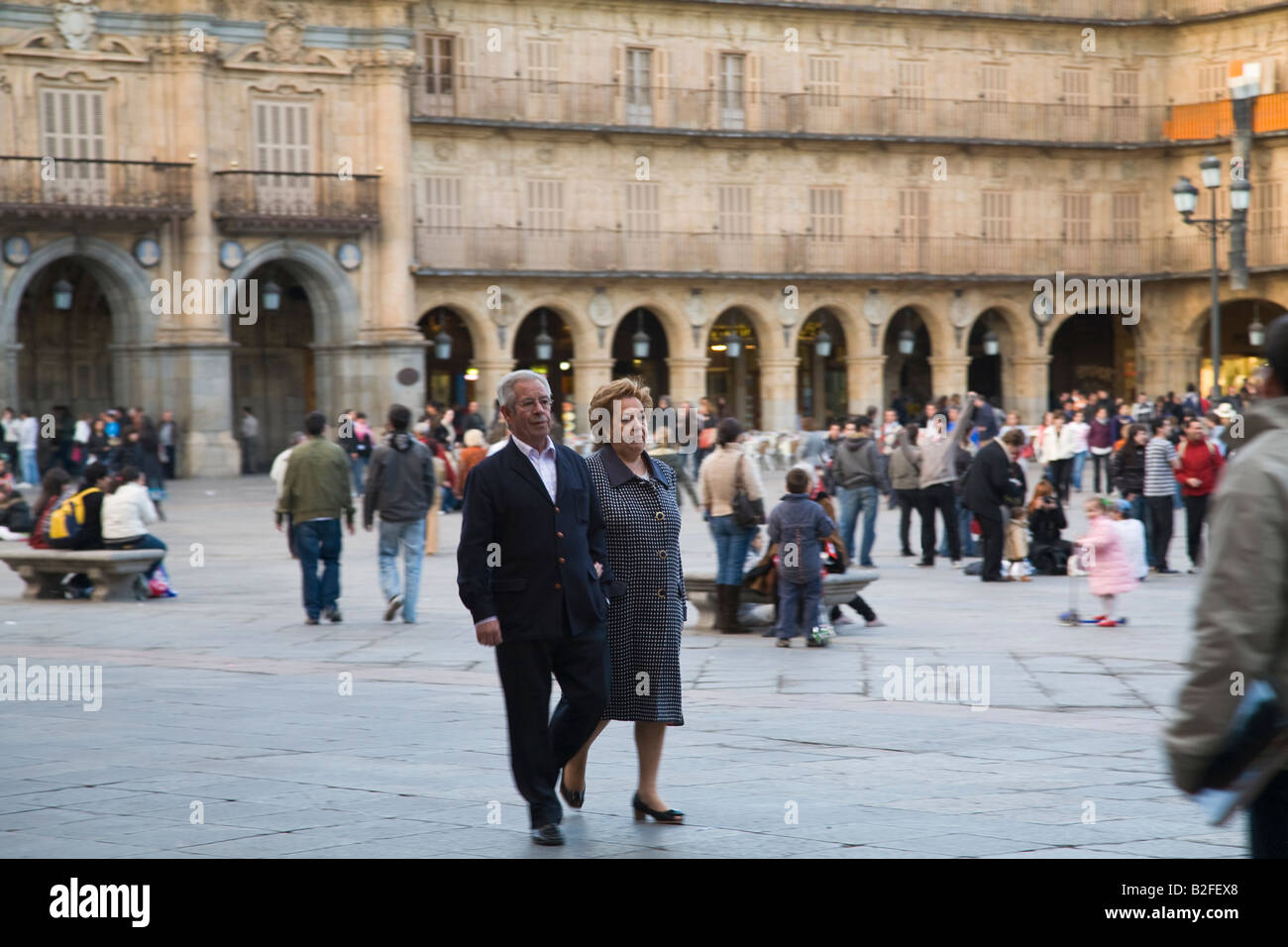 SPAIN Salamanca Older couple walk together through Plaza Mayor public square built in 1700 s crowds of people and tour groups Stock Photo