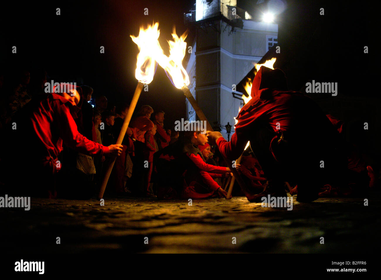Two men in historic costumes with burning torches at night street in medieval Banska Stiavnica town, festival, Slovakia summer Stock Photo