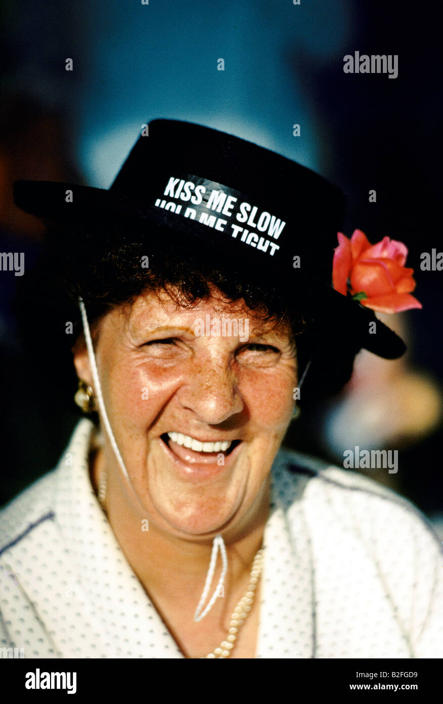 a woman wearing novelty hat smiling on holiday in blackpool, uk Stock Photo