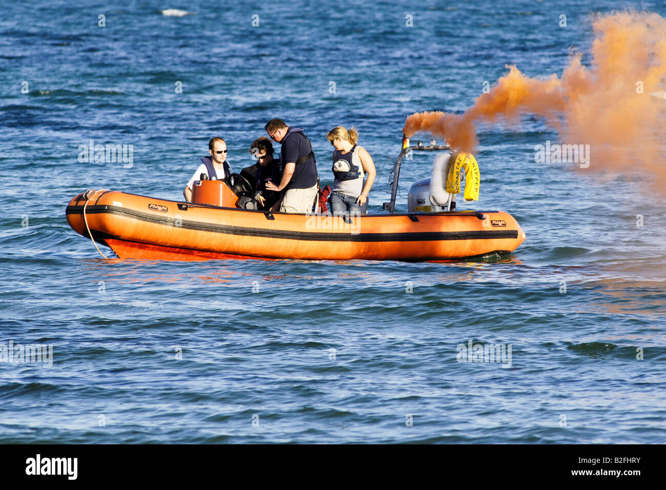 An orange flare smoking from a boat during an exercise to say someone has gone missing in the water Stock Photo