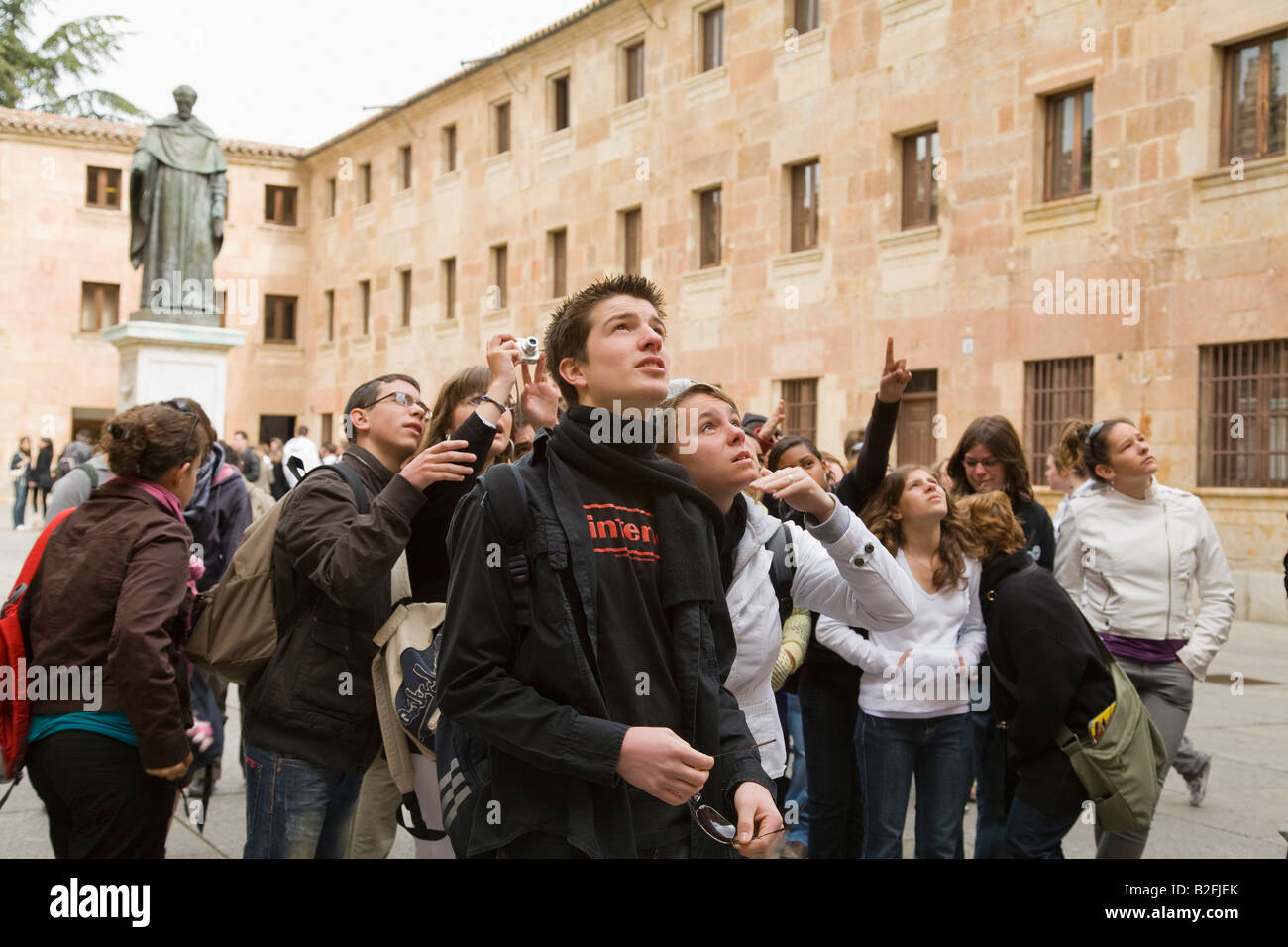 SPAIN Salamanca Group of students look for frog on ornately decorated facade of University of Salamanca Stock Photo