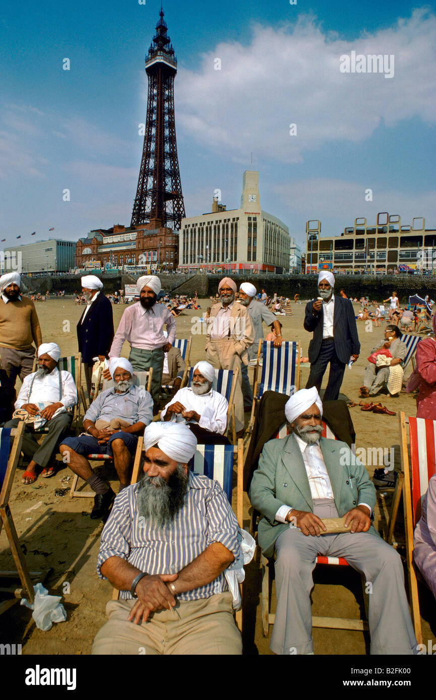 Asian men wearing turbans, sitting in deckchairs in front of the Blackpool Tower Stock Photo