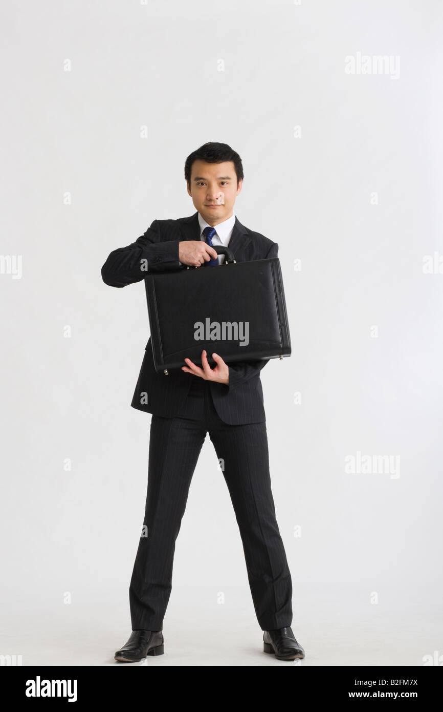 Portrait of a businessman holding a briefcase Stock Photo - Alamy