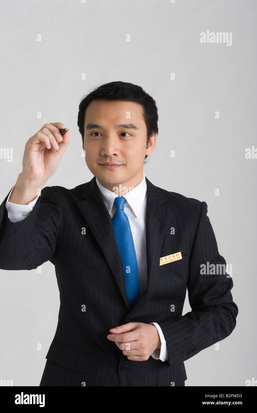Businessman holding a pen Stock Photo - Alamy