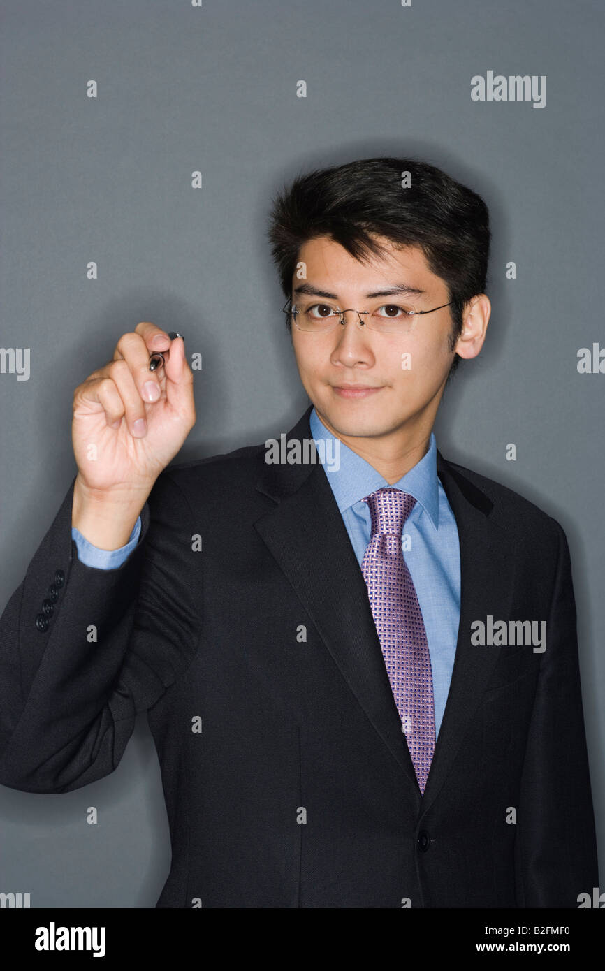 Portrait of a businessman holding a pen Stock Photo - Alamy