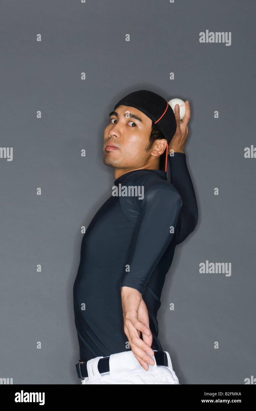 Adult baseball pitcher throwing ball hires stock photography and