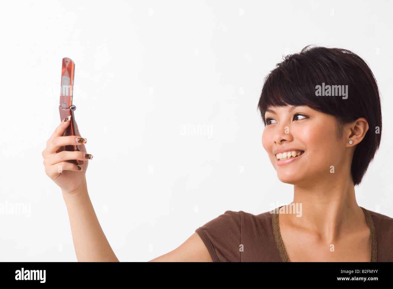 Close-up of a young woman text messaging and smiling Stock Photo - Alamy