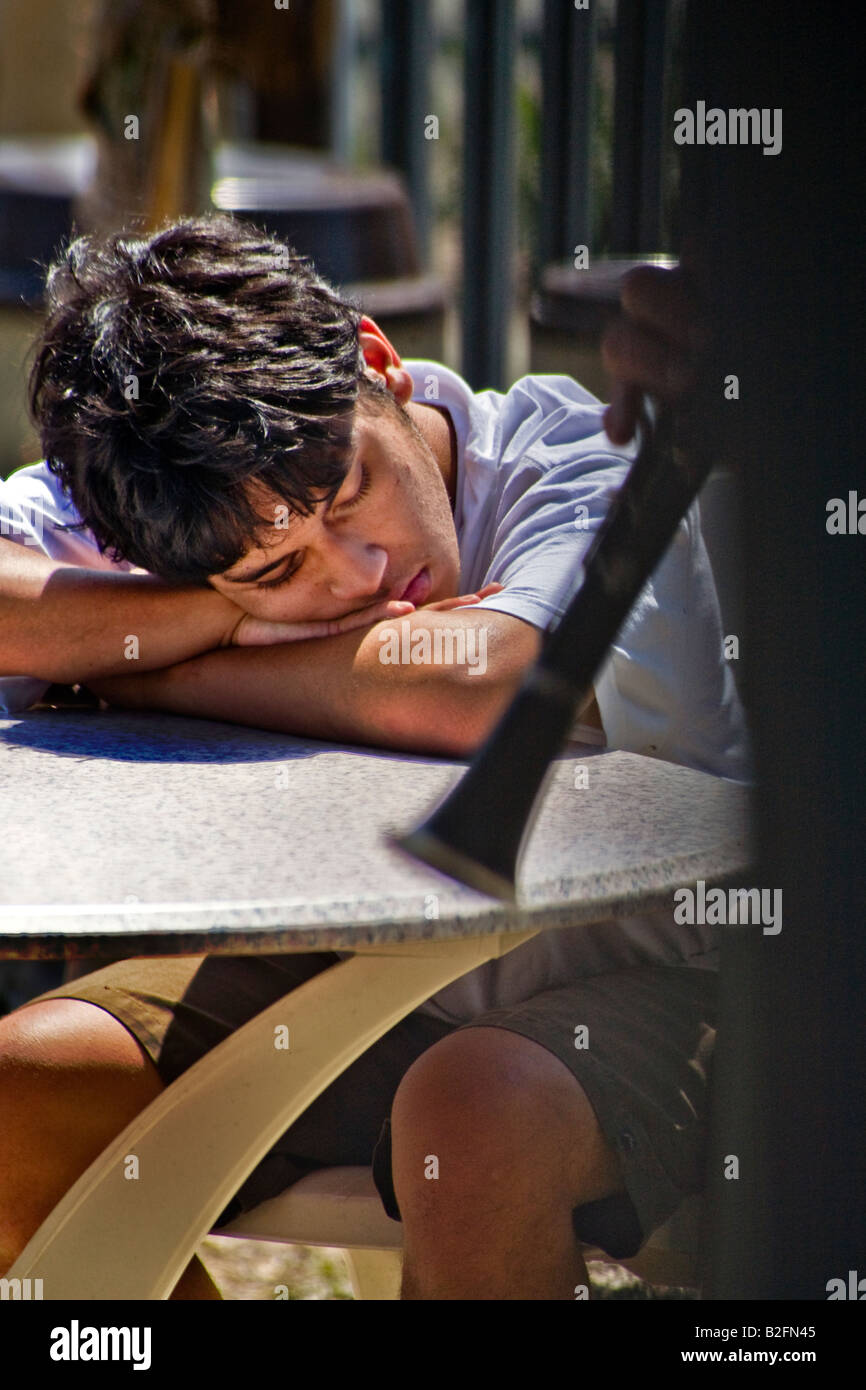 A young Hispanic man listens intently to Le Jazz Hot music at outdoor band performsnce in Coronado CA Note clarinet foreground Stock Photo