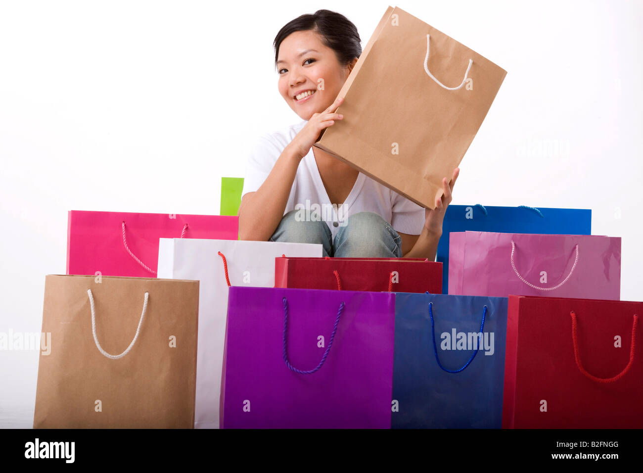 Portrait of a young woman holding a shopping bag and smiling Stock ...