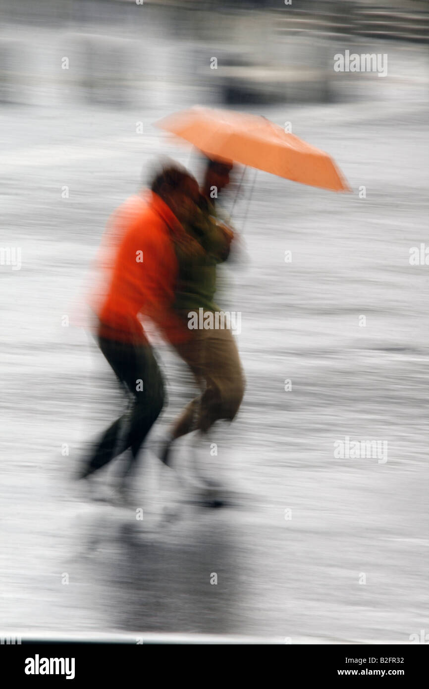 couple sharing an umbrella in rain in town Stock Photo - Alamy