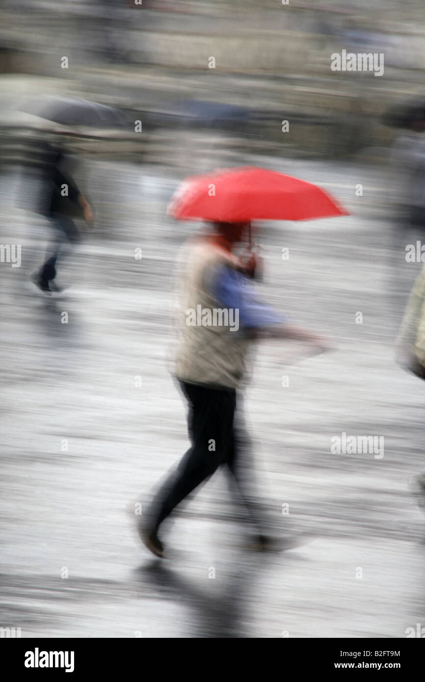 man with umbrella running in heavy rain in town Stock Photo - Alamy
