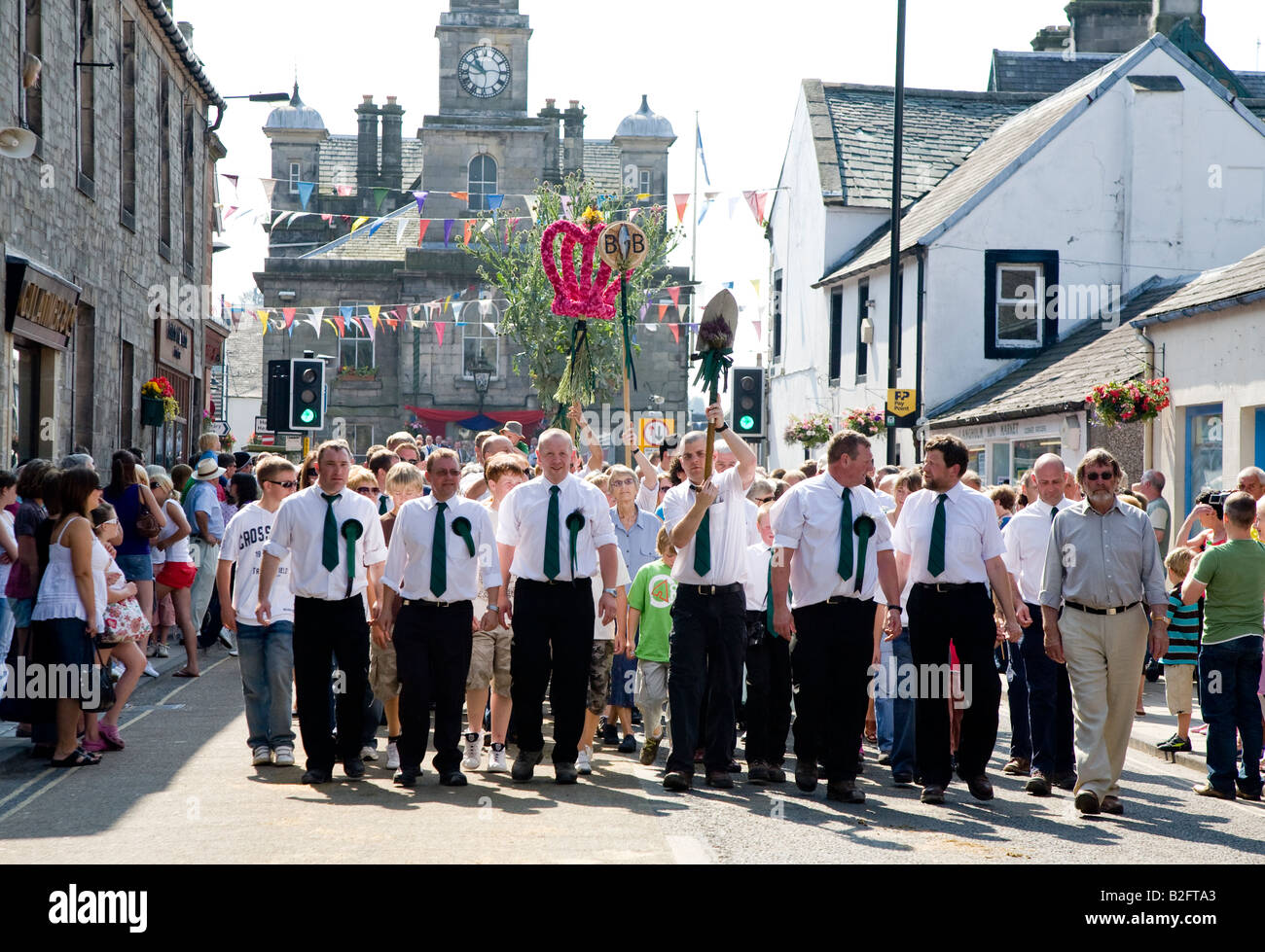 Townspeople Carrying Spade Thistle And Royal Emblems  Langholm Common Riding Langholm Scotland UK Stock Photo