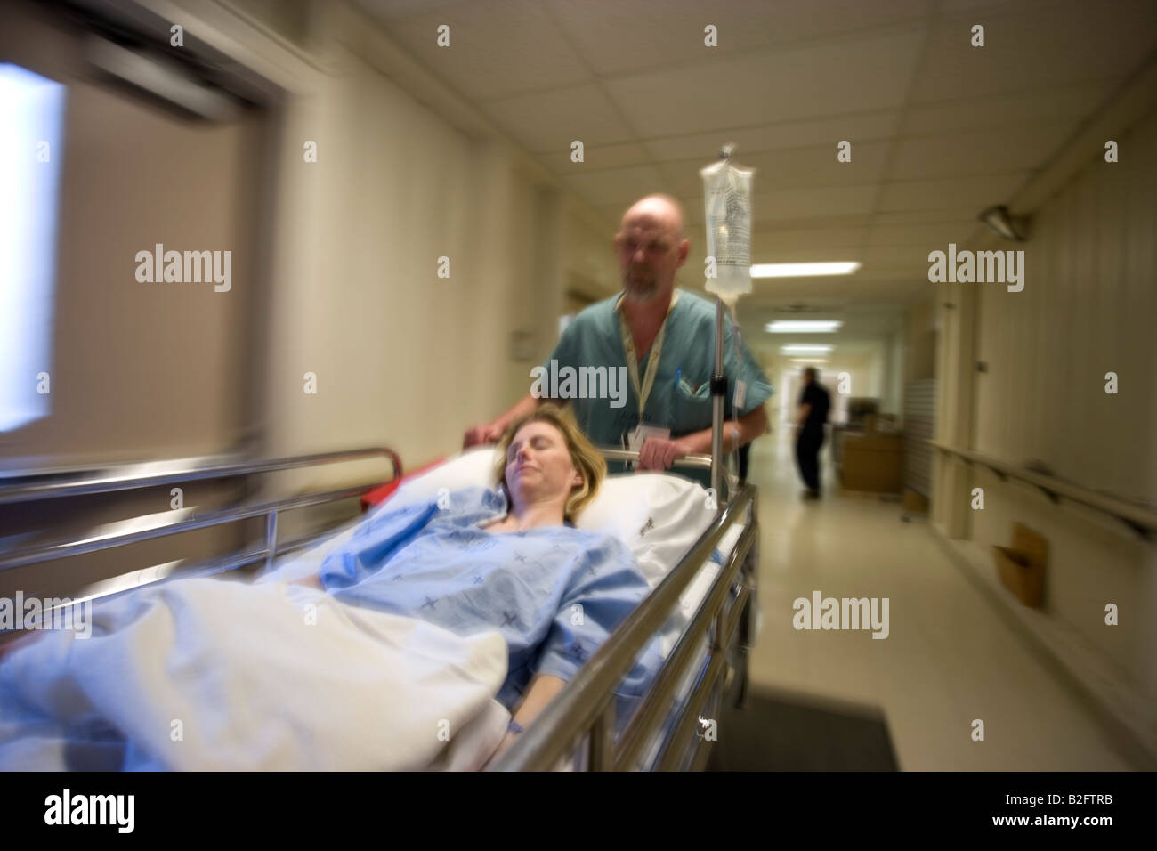 Patient being transported on gurney in hospital hires stock