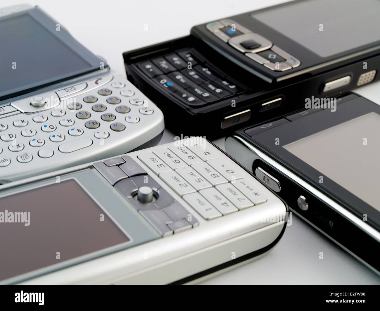 Stack Pile of Several Modern Mobile Phones PDA Cell Handheld Units Isolated on White Background Stock Photo