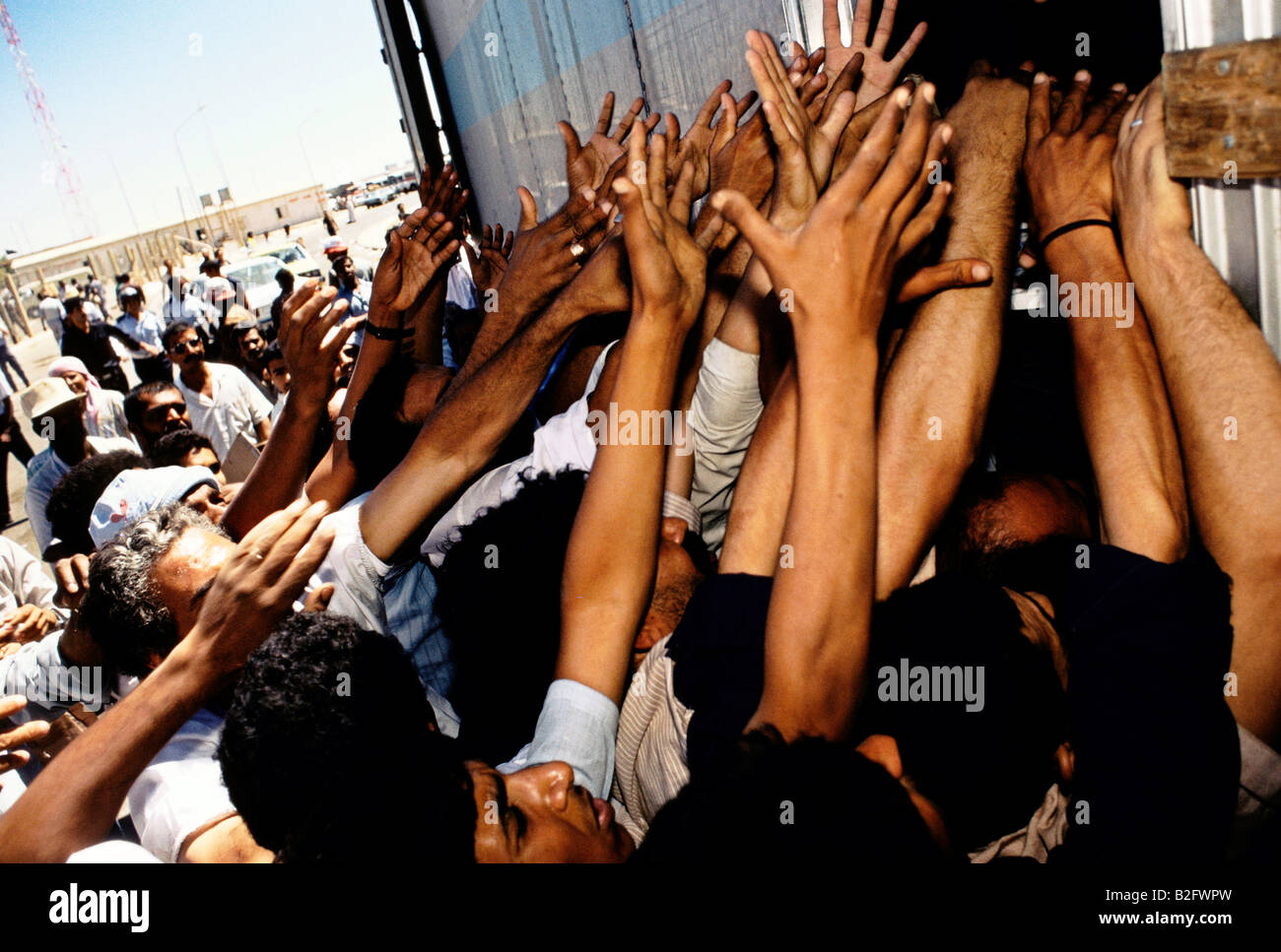 hands reaching up to receive food aid from refugee camp amman, jordan, gulf crisis Stock Photo