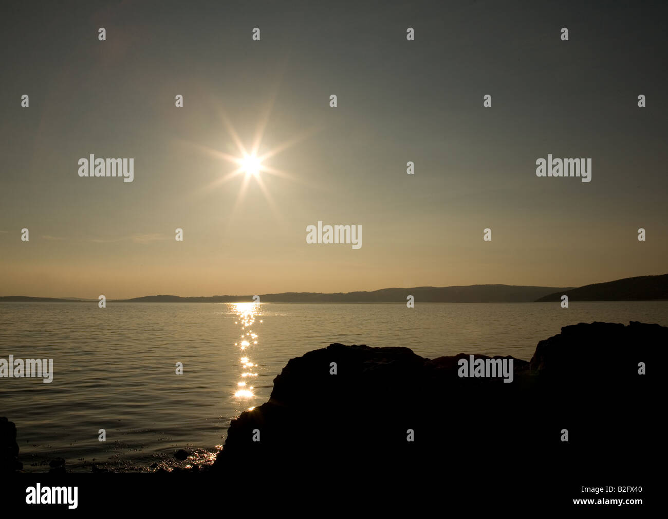 The sun sets over the rock pools of Morecambe Bay at Silverdale ...