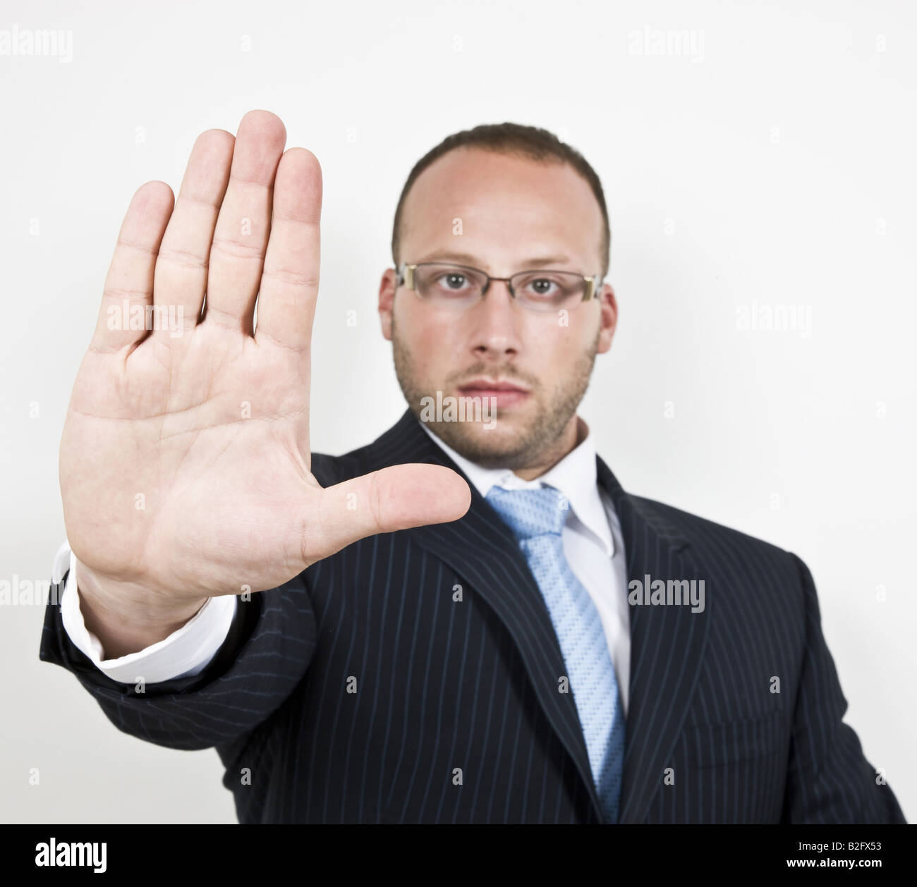 warning businessman holding his right hand up in a stop warning sign Stock Photo