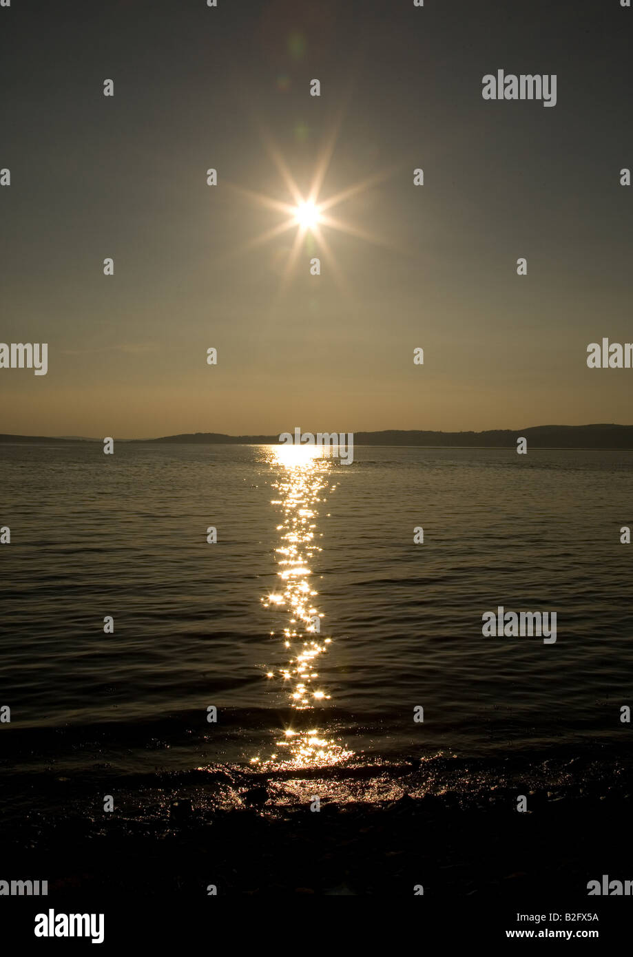 The sun sets over the rock pools of Morecambe Bay at Silverdale ...