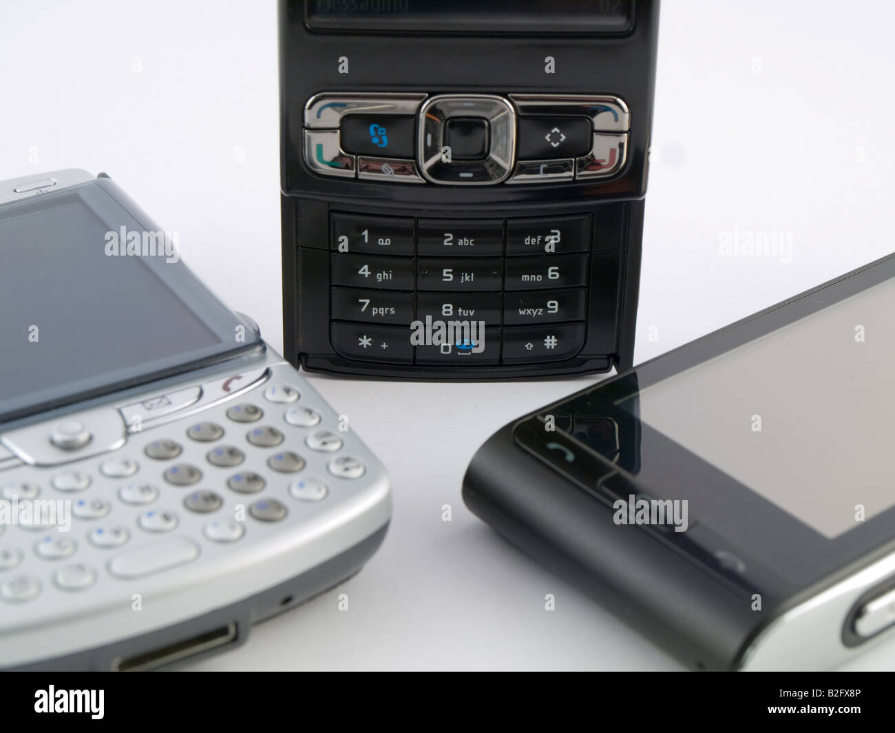 Stack Pile of Several Modern Mobile Phones PDA Cell Handheld Units Isolated on White Background Stock Photo