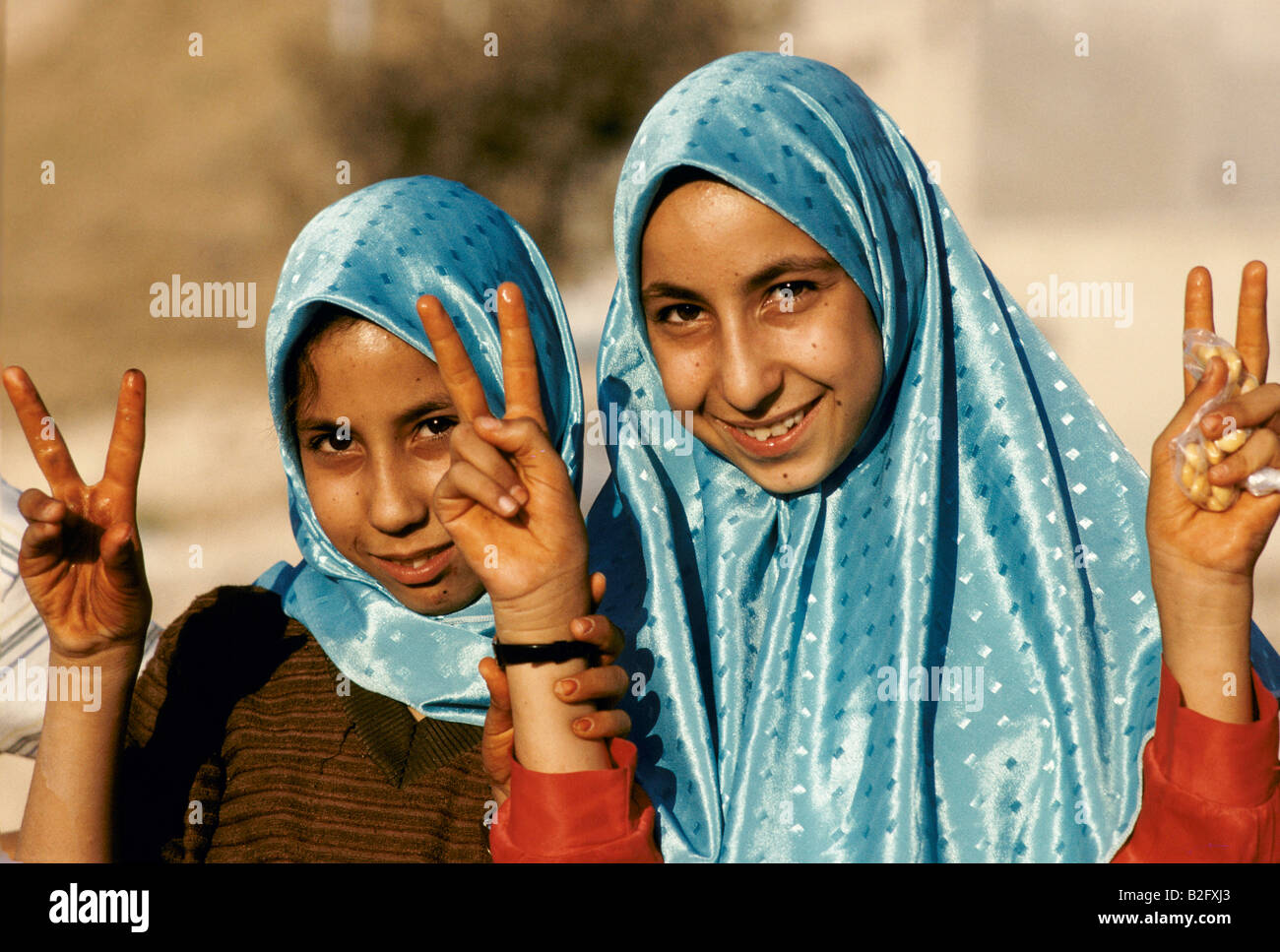two muslim girls in headscarfs making the peace sign at palestinian demonstration, amman Stock Photo