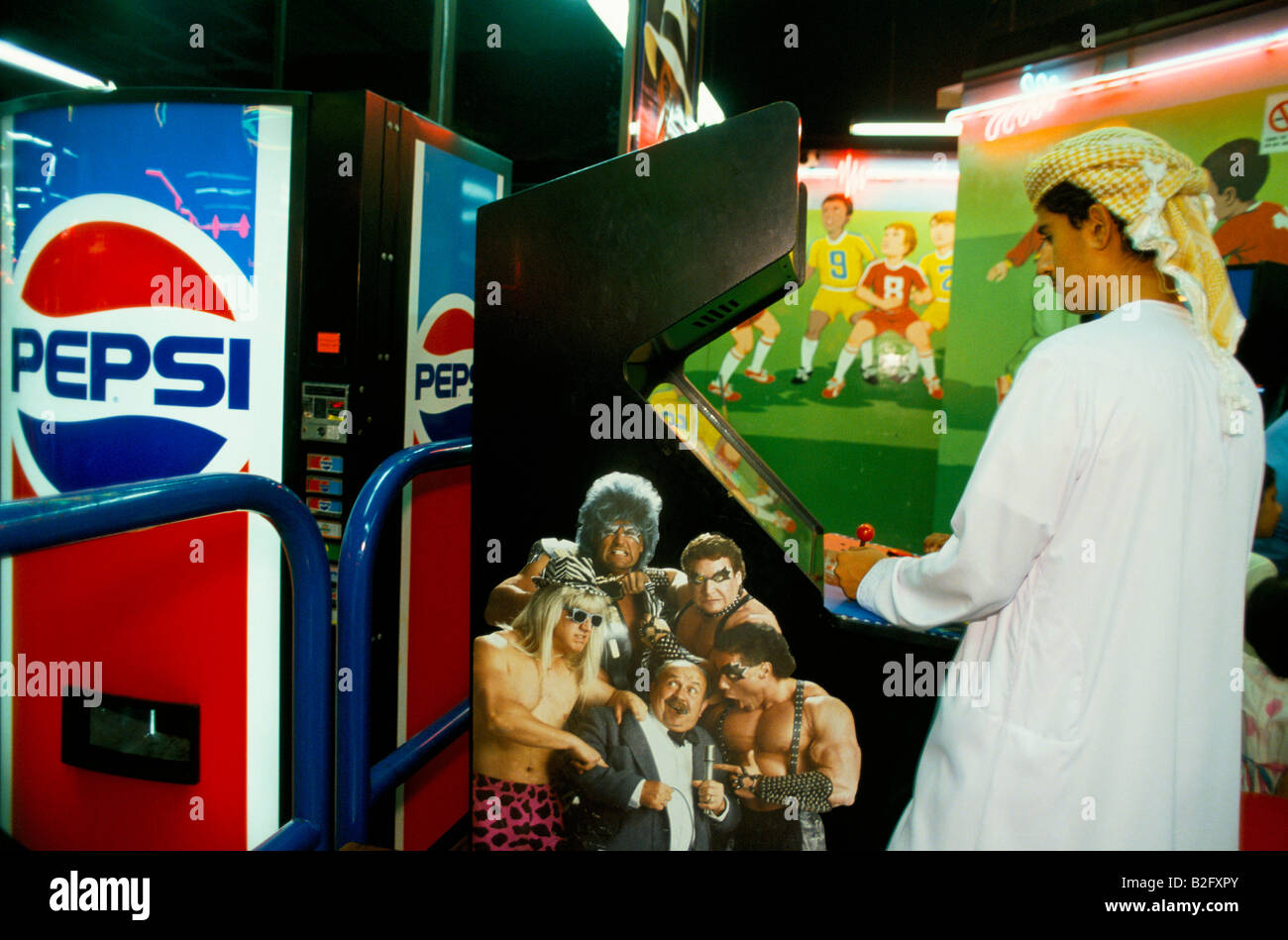 a youth wearing kandura plays arcade game in sinbads amusment centre dubai Stock Photo
