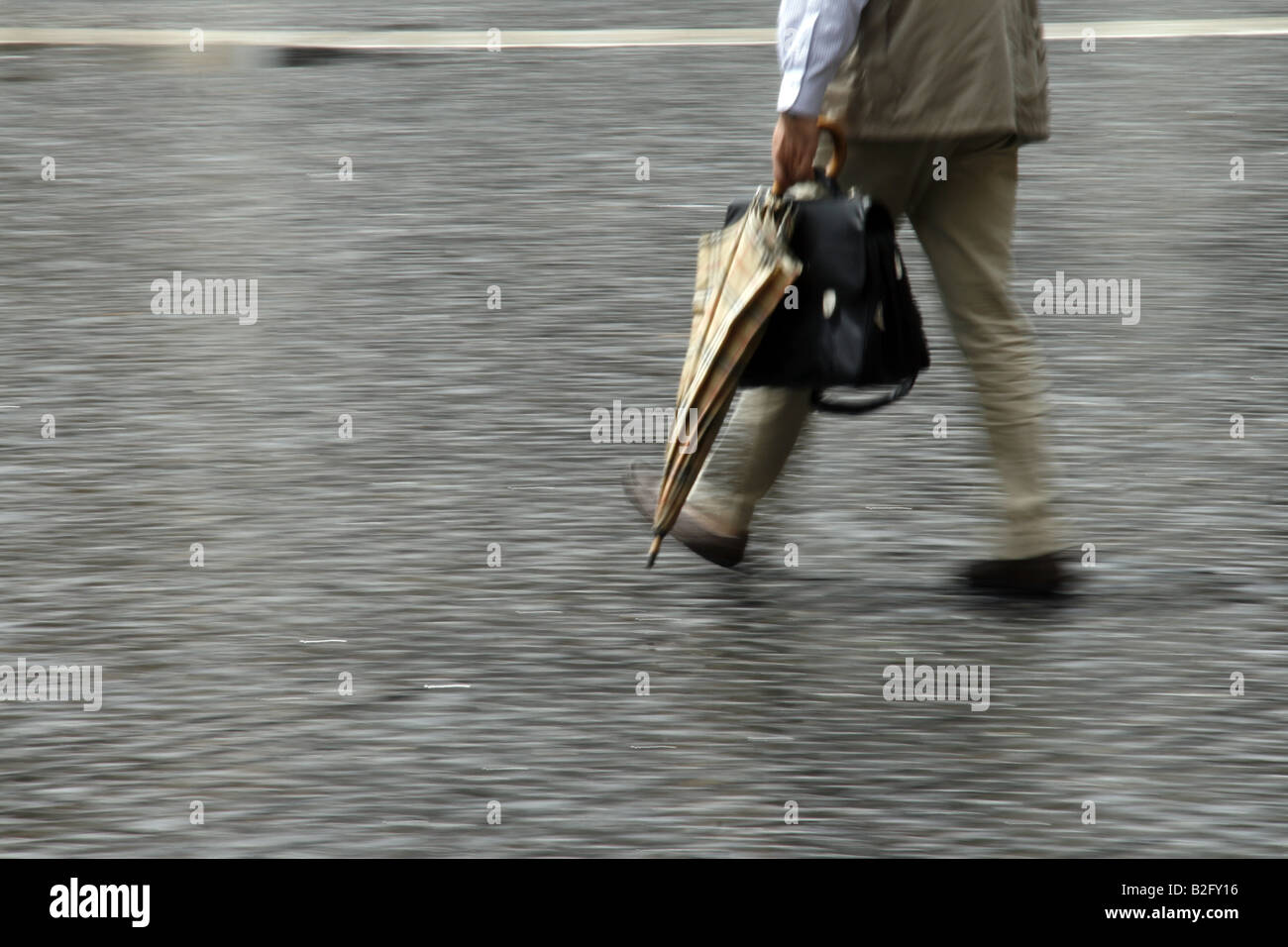 person carrying closed umbrella in town Stock Photo Alamy