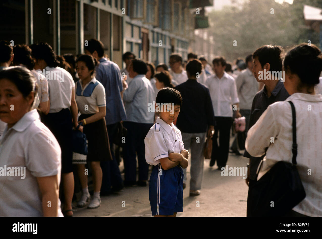 boy standing alone on a street in china Stock Photo