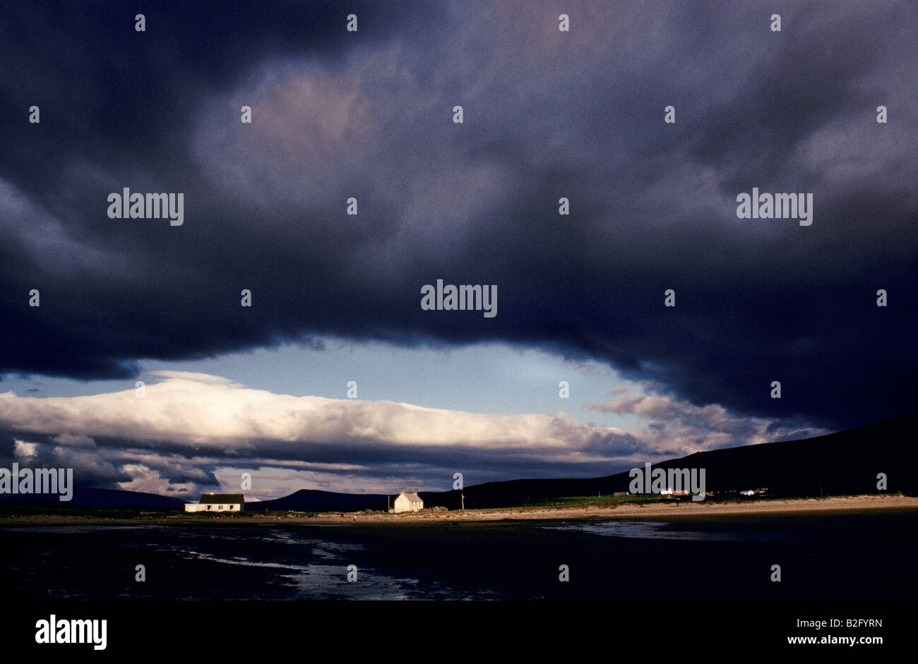 DINGLE PENINSULA ATMOSPHERIC CLOUDS GATHER IN THE SKIES ABOVE COTTAGES IN THE DINGLE PENINSULA IRELAND 1991 Stock Photo